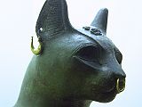 British Museum Top 20 11-2 Gayer-Anderson Cat Close Up 11. Gayer-Anderson Cat  Saqqara Egypt, after 600BC, 42cm high. Here is a close up showing the gold rings, a silvered collar round its neck and a silver protective wedjat eye amulet.